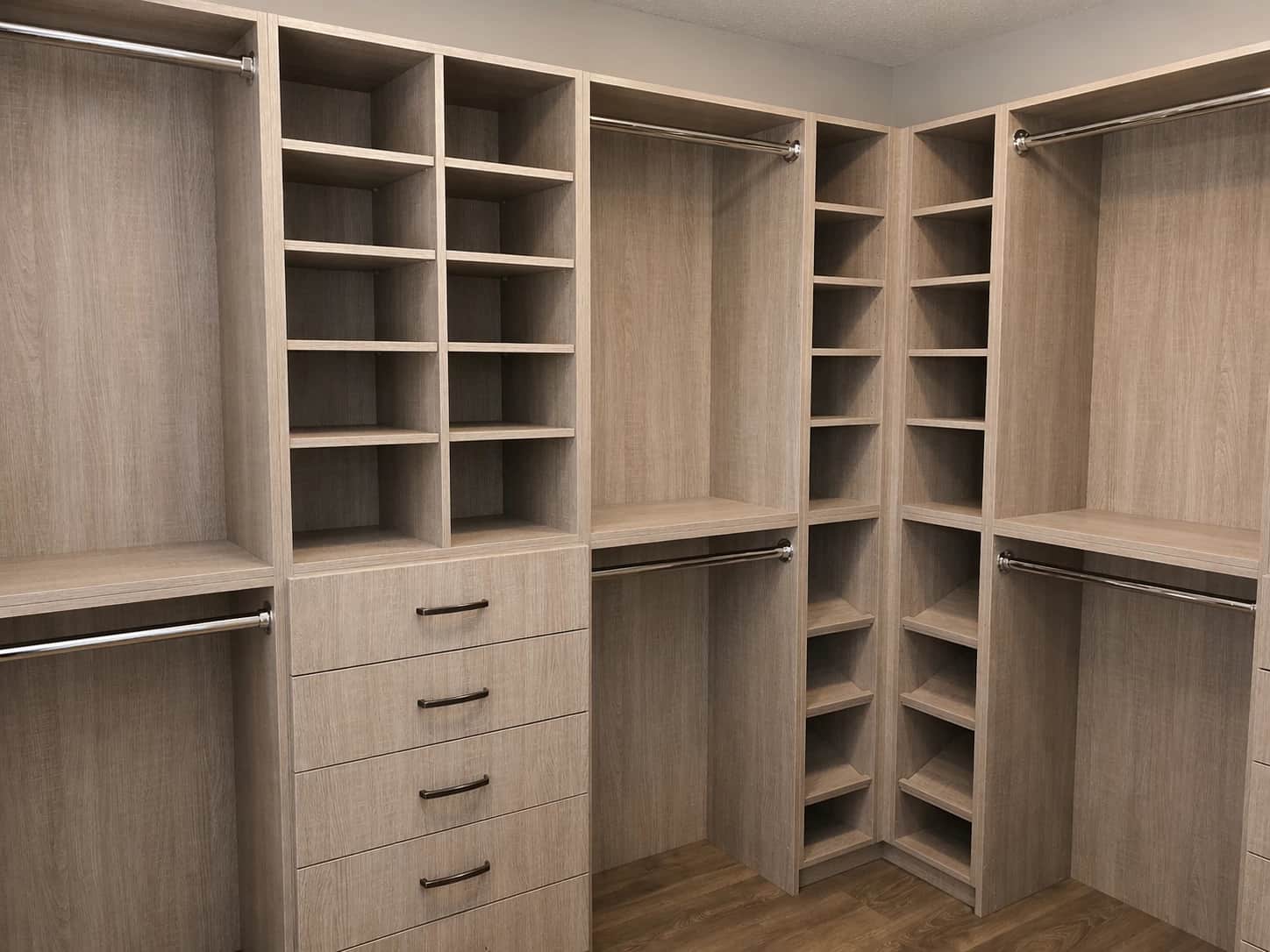 Light walnut walk-in closet organizer with drawers and shelving