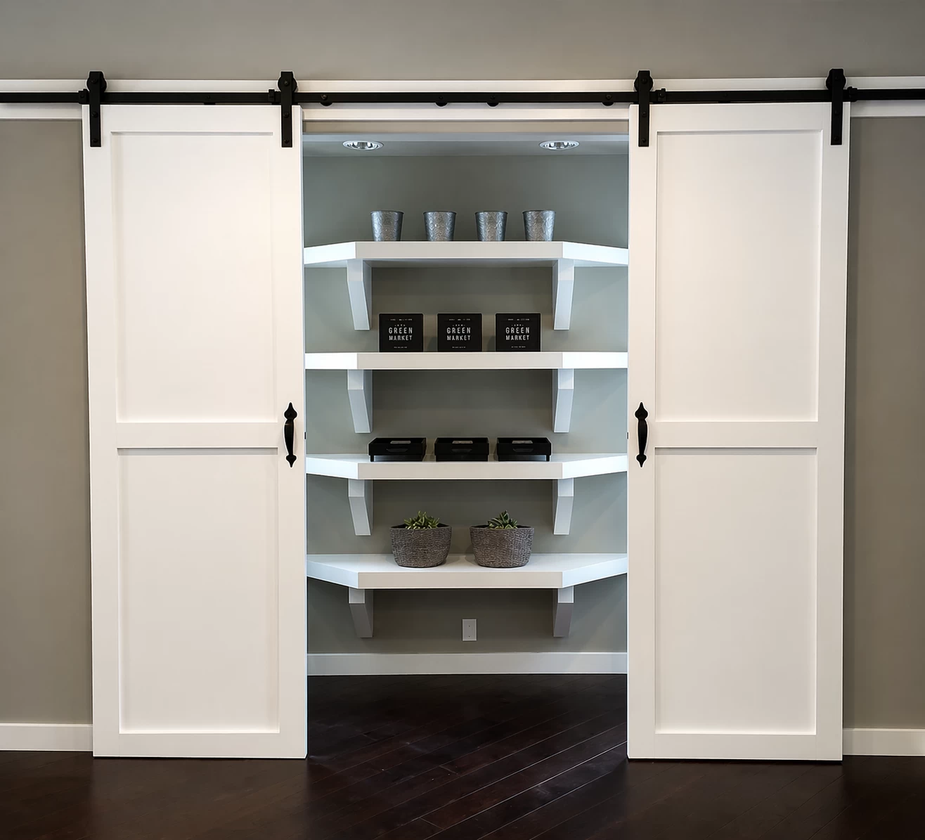 Pantry with sliding white barn doors revealing floating shelves