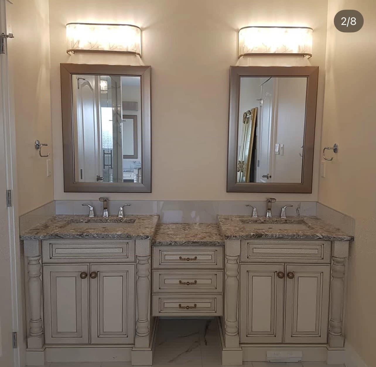 Double vanity with ornate posts and framed mirrors