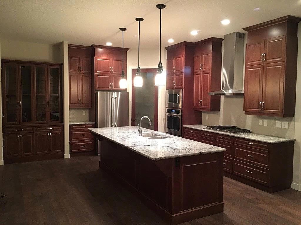 Cherry kitchen with white granite island and pendant lighting