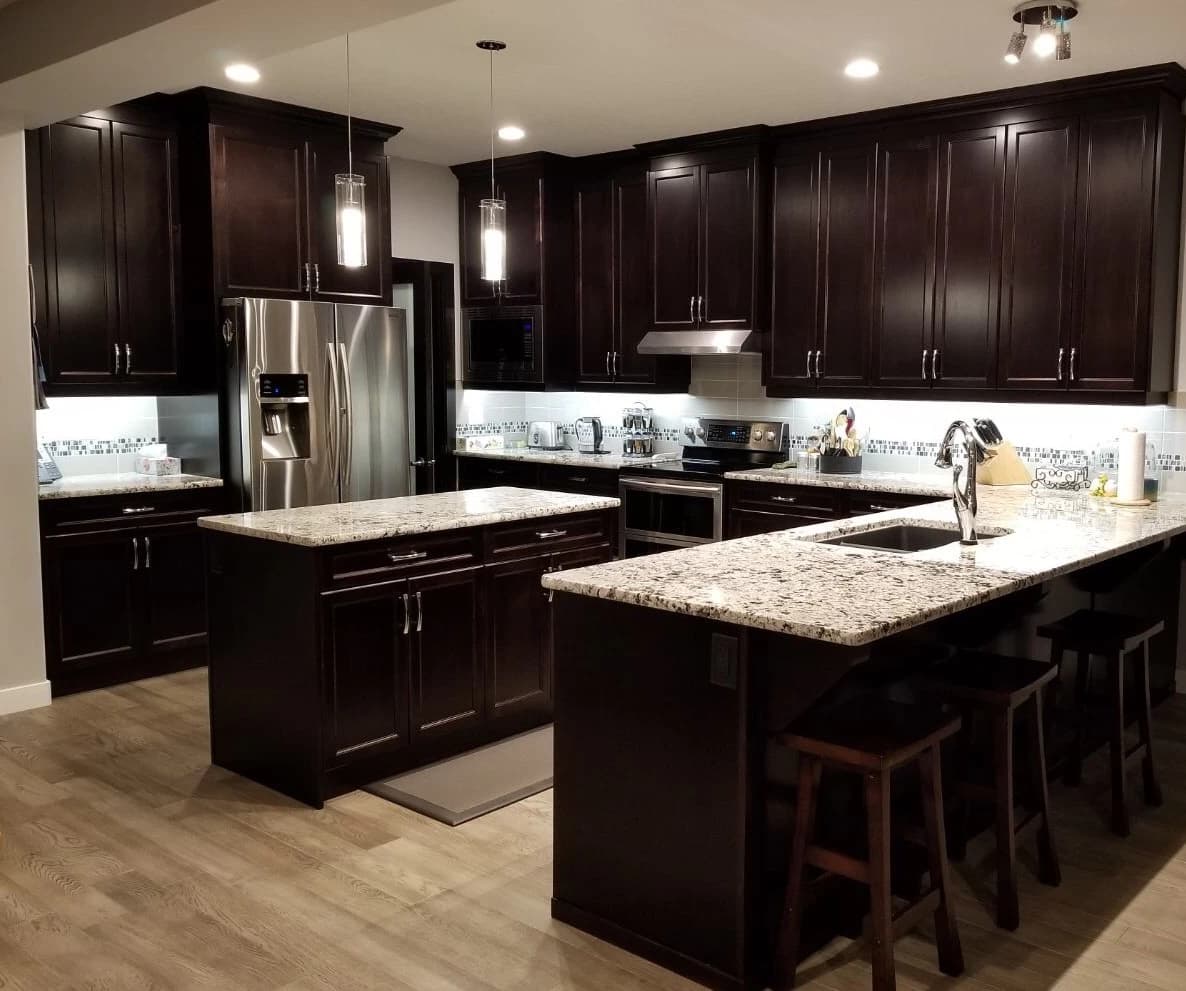 Espresso shaker kitchen with granite island and tile backsplash