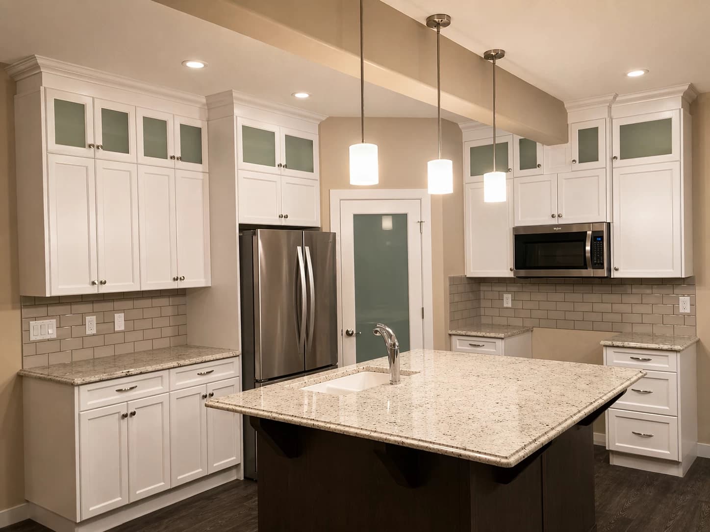 White kitchen with frosted uppers and granite island